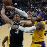 
              San Antonio Spurs forward Keldon Johnson (3) is fouled by Los Angeles Lakers forward Carmelo Anthony, right, as he drives to the basket during the second half of an NBA basketball game, Monday, March 7, 2022, in San Antonio. (AP Photo/Eric Gay)
            