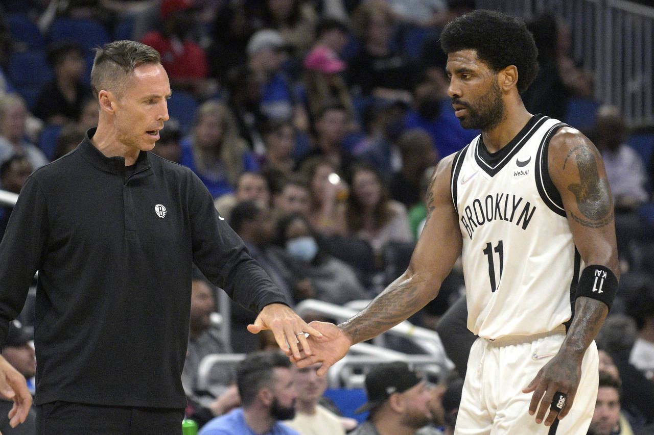 Brooklyn Nets coach Steve Nash, left, greets guard Kyrie Irving (11) during a timeout in the first ...