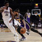 
              Philadelphia 76ers center Joel Embiid (21) defends against Los Angeles Lakers guard D.J. Augustin (4) during the first half of an NBA basketball game in Los Angeles, Wednesday, March 23, 2022. (AP Photo/Ashley Landis)
            
