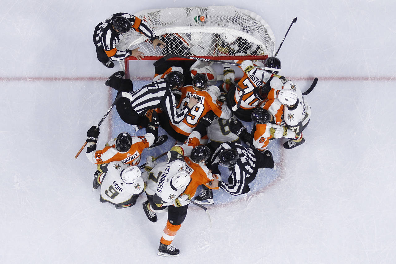Philadelphia Flyers players and Vegas Golden Knights players wrestle during the first period of an ...