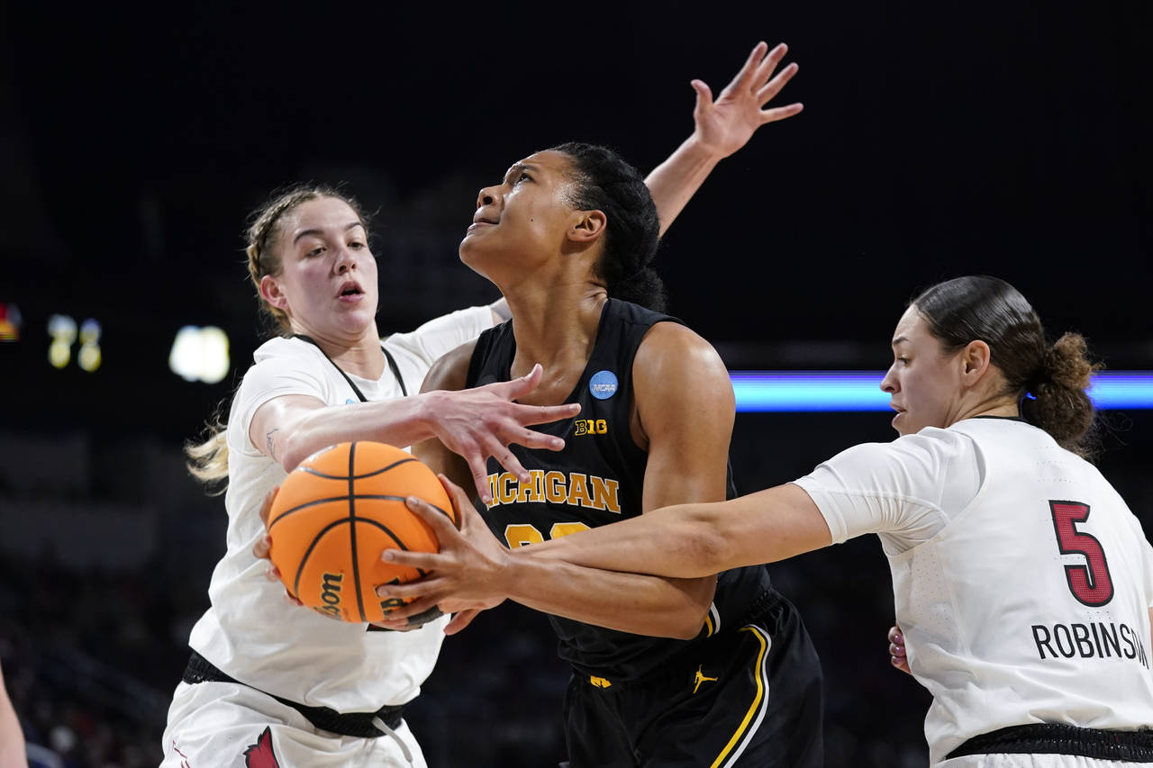 Michigan forward Naz Hillmon (00) is fouled by Louisville guard Mykasa Robinson (5) while Emily Eng...