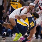 
              Indiana Pacers guard Justin Anderson (10) and Portland Trail Blazers guard Josh Hart, top, collide as they go for the ball during the second half of an NBA basketball game in Indianapolis, Sunday, March 20, 2022. (AP Photo/Michael Conroy)
            