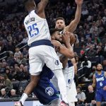 
              Minnesota Timberwolves center Karl-Anthony Towns, center, is caught between Dallas Mavericks guard Reggie Bullock (25) and forward Maxi Kleber during the first half of an NBA basketball game Friday, March 25, 2022, in Minneapolis. (AP Photo/Craig Lassig)
            