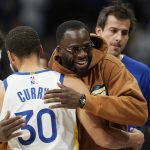 
              Golden State Warriors guard Steph Curry (30) is hugged by injured teammate Draymond Green before the team's NBA basketball game against the Denver Nuggets on Thursday, March 10, 2022, in Denver. (AP Photo/David Zalubowski)
            