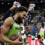 
              Minnesota Timberwolves center Karl-Anthony Towns is doused by teammate D'Angelo Russell, rear, after an NBA basketball game against the San Antonio Spurs on Monday, March 14, 2022, in San Antonio. (AP Photo/Darren Abate)
            