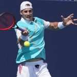 
              John Isner, of the United States, returns the ball to Hugo Gaston, of France, during the Miami Open tennis tournament, Friday, March 25, 2022, in Miami Gardens, Fla. (AP Photo/Marta Lavandier)
            
