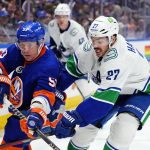 
              New York Islanders' Casey Cizikas (53) fights for control of the puck with Vancouver Canucks' Travis Hamonic (27) during the second period of an NHL hockey game Thursday, March 3, 2022, in Elmont, N.Y. (AP Photo/Frank Franklin II)
            