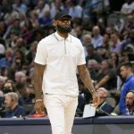 
              Los Angeles Lakers forward LeBron James walks the floor in street clothes during the first quarter of an NBA basketball game against the Dallas Mavericks in Dallas, Tuesday, March 29, 2022. (AP Photo/LM Otero)
            