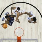 
              St. Peter's KC Ndefo, left, goes up for a shot against North Carolina's Armando Bacot, center, and Leaky Black during the first half of a college basketball game in the Elite 8 round of the NCAA tournament, Sunday, March 27, 2022, in Philadelphia. (AP Photo/Chris Szagola)
            