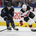 
              New Jersey Devils center Nico Hischier (13) moves the puck up ice as Toronto Maple Leafs right wing Ilya Mikheyev (65) defends during the third period of an NHL hockey game Wednesday, March 23, 2022, in Toronto. (Frank Gunn/The Canadian Press via AP)
            