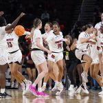 
              Louisville players celebrate their 62-50 win against Michigan after a college basketball game in the Elite 8 round of the NCAA women's tournament Monday, March 28, 2022, in Wichita, Kan. (AP Photo/Jeff Roberson)
            