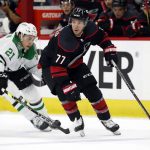 
              Carolina Hurricanes' Tony DeAngelo (77) controls the puck in front of Dallas Stars' Jason Robertson (21) during the first period of an NHL hockey game in Raleigh, N.C., Thursday, March 24, 2022. (AP Photo/Karl B DeBlaker)
            