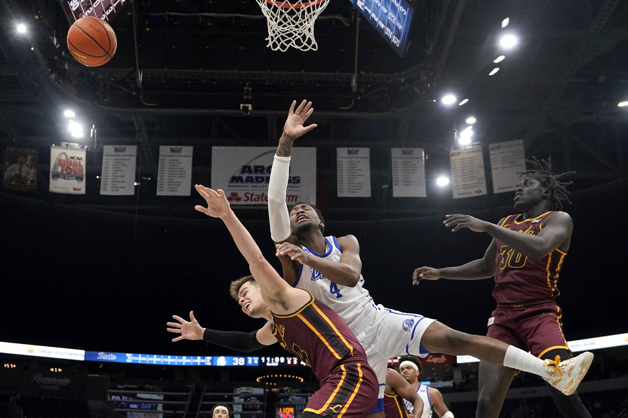 Drake's ShanQuan Hemphill, center, loses control of the ball as Loyola of Chicago's Braden Norris, ...