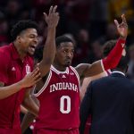 
              Indiana guard Xavier Johnson (0) celebrates in front of center Michael Durr, left, in the second half of an NCAA college basketball game against Michigan at the Big Ten Conference tournament in Indianapolis, Thursday, March 10, 2022. Indiana defeated Michigan 74-69. (AP Photo/Michael Conroy)
            