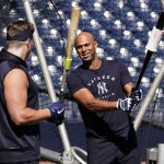 
              New York Yankees infielder Luke Voit, left, and outfielder Aaron Hicks talk outside the batting cage during a spring training baseball workout, Sunday, March 13, 2022, in Tampa, Fla. (AP Photo/John Raoux)
            