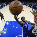 
              Philadelphia 76ers' Joel Embiid, center, goes up for a shot against Cleveland Cavaliers' Jarrett Allen during the first half of an NBA basketball game, Friday, March 4, 2022, in Philadelphia. (AP Photo/Matt Slocum)
            
