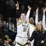 
              Baylor forward Caitlin Bickle (51) and the rest of the bench celebrates a teammate's 3-point basket as Baylor head coach Nicki Collen, lower right, looks on during the second half of an NCAA college basketball game against Oklahoma in the semifinal round of the Big 12 Conference tournament in Kansas City, Mo., Saturday, March 12, 2022. (AP Photo/Reed Hoffmann)
            