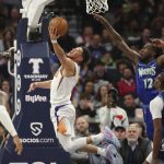 
              Phoenix Suns guard Devin Booker (1) shoots on Minnesota Timberwolves forward Taurean Prince (12) as Timberwolves guard Jaylen Nowell (4) and center Naz Reid (11) watch during the second half of an NBA basketball game Wednesday, March 23, 2022, in Minneapolis. (AP Photo/Andy Clayton-King)
            