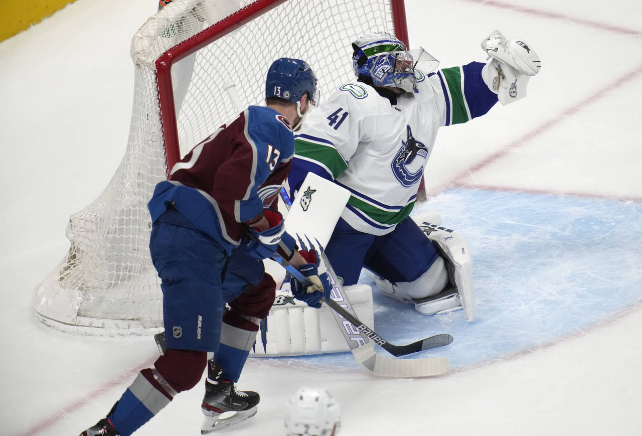 Vancouver Canucks goaltender Jaroslav Halak, right, makes a glove save as Colorado Avalanche right ...
