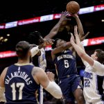 
              New Orleans Pelicans forward Herbert Jones (5) shoots from between Orlando Magic forward Franz Wagner (22) and center Mo Bamba (5) during the first quarter of an NBA basketball game in New Orleans, Wednesday, March 9, 2022. (AP Photo/Derick Hingle)
            