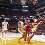 
              Arkansas guard Chris Lykes (11) falls to the floor as he shoots over Tennessee guard Josiah-Jordan James (30) during the second half of an NCAA college basketball game Saturday, March 5, 2022, in Knoxville, Tenn. (AP Photo/Wade Payne)
            