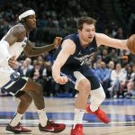 
              Dallas Mavericks guard Luka Doncic (77) handles the ball against Minnesota Timberwolves forward Jarred Vanderbilt, left, during the first quarter of an NBA basketball game in Dallas, Monday, March 21, 2022. (AP Photo/LM Otero)
            