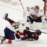 
              Florida Panthers goaltender Sergei Bobrovsky (72) makes a save as Ottawa Senators' Austin Watson (16) and Panthers' Claude Giroux (28) fall during the second period of an NHL hockey game Saturday, March 26, 2022, in Ottawa, Ontario. (Patrick Doyle/The Canadian Press via AP)
            