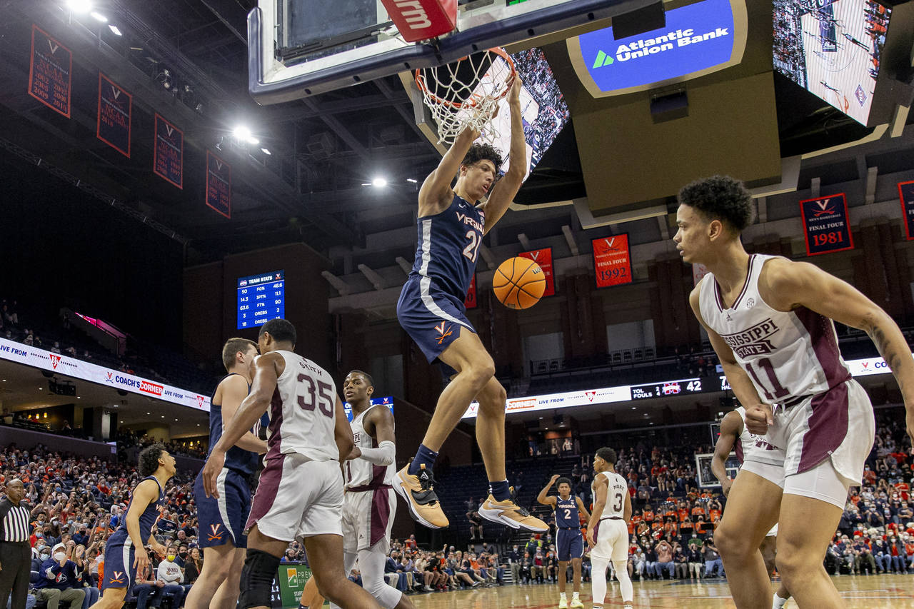 Virginia forward Kadin Shedrick (21) hangs from the basket after a dunk during the second half agai...