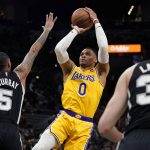 
              Los Angeles Lakers guard Russell Westbrook (0) shoots over San Antonio Spurs guard Dejounte Murray (5) during the first half of an NBA basketball game, Monday, March 7, 2022, in San Antonio. (AP Photo/Eric Gay)
            