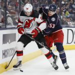 
              New Jersey Devils' Jack Hughes, left, tries to control the puck as Columbus Blue Jackets' Gabriel Carlsson defends during the first period of an NHL hockey game Tuesday, March 1, 2022, in Columbus, Ohio. (AP Photo/Jay LaPrete)
            