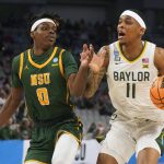 
              Baylor guard James Akinjo (11) drives against Norfolk State guard Christian Ings (0) during the first half of a college basketball game in the first round of the NCAA tournament in Fort Worth, Texas, Thursday, March 17, 2022. (AP Photo/LM Otero)
            