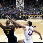 
              West Virginia forward Gabe Osabuohien (3) shoots under pressure from Kansas forward Mitch Lightfoot (44) during the first half of an NCAA college basketball game in the quarterfinal round of the Big 12 Conference tournament in Kansas City, Mo., Thursday, March 10, 2022. (AP Photo/Charlie Riedel)
            