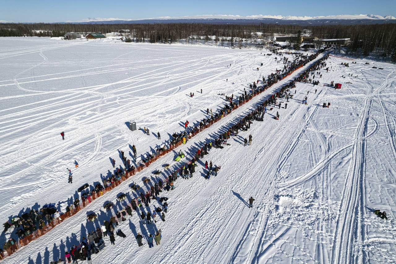 FILE - A competitor mushes across Willow Lake during the restart of the Iditarod Trail Sled Dog Rac...