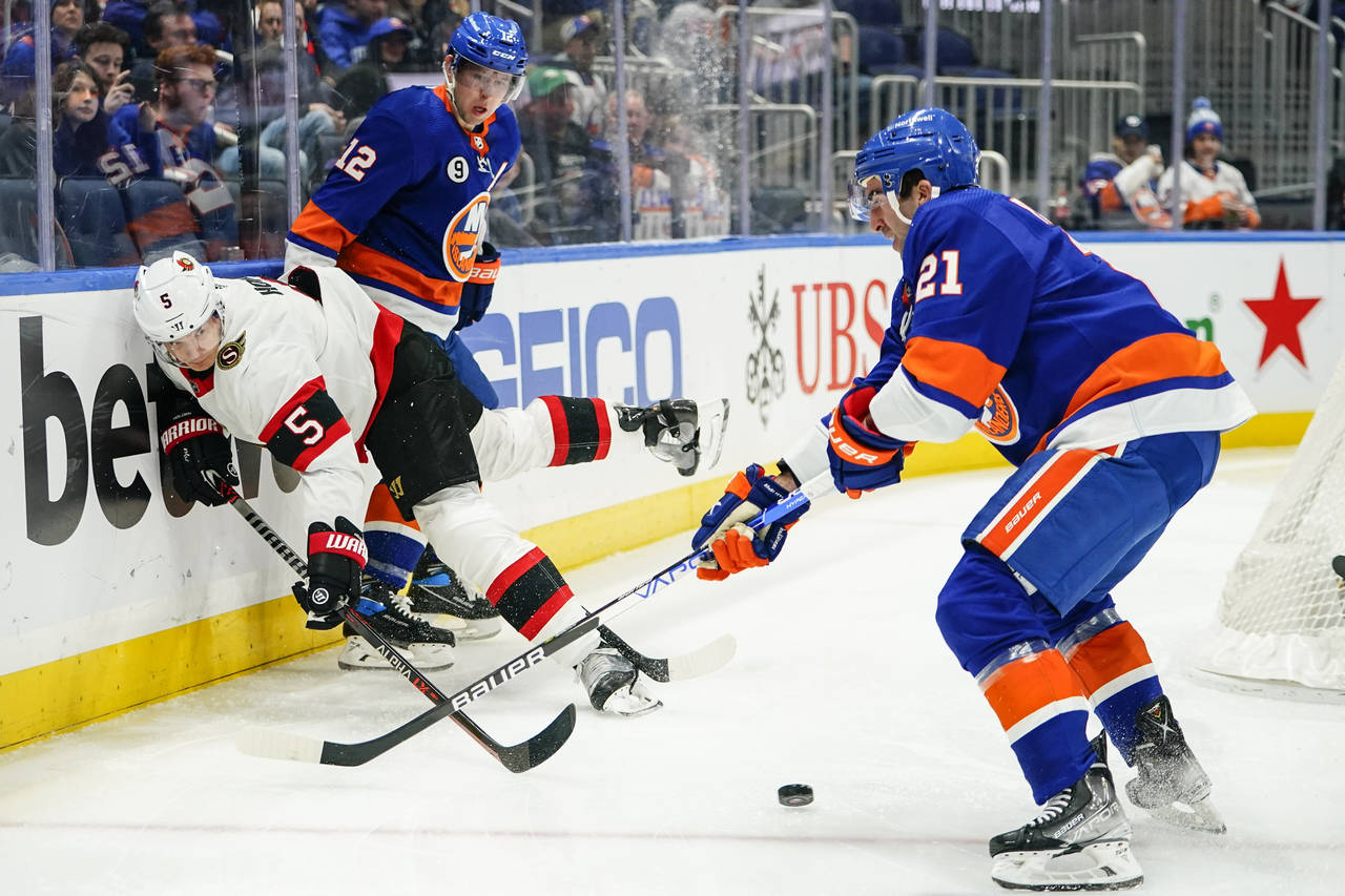 Ottawa Senators' Nick Holden (5) vies for control of the puck with New York Islanders' Josh Bailey ...