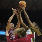
              South Dakota center Hannah Sjerven (34) and Baylor center Queen Egbo jump for a rebound during the first half of a college basketball game in the second round of the NCAA tournament in Waco, Texas, Sunday, March 20, 2022. (AP Photo/LM Otero)
            