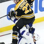 
              Boston Bruins defenseman Hampus Lindholm (27) hovers over Tampa Bay Lightning right wing Corey Perry (10) during the first period of an NHL hockey game, Thursday, March 24, 2022, in Boston. (AP Photo/Charles Krupa)
            