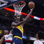 
              Indiana Pacers forward Jalen Smith (25) shoots in front of Portland Trail Blazers guard Kris Dunn, left, during the second half of an NBA basketball game in Indianapolis, Sunday, March 20, 2022. (AP Photo/Michael Conroy)
            