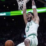 
              Boston Celtics forward Jayson Tatum (0) yells as he hangs on the rim on a dunk during the second half of an NBA basketball game against the Memphis Grizzlies, Thursday, March 3, 2022 in Boston. Tatum scored 37 points as the Celtics defeated the Grizzlies 120-107. (AP Photo/Charles Krupa)
            