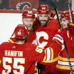 
              Calgary Flames' Erik Gudbranson, center right, celebrates his goal against the Los Angeles Kings with Trevor Lewis, second from left, and Sean Monahan, right, during the third period of an NHL hockey game Thursday, March 31, 2022, in Calgary, Alberta. (Jeff McIntosh/The Canadian Press via AP)
            