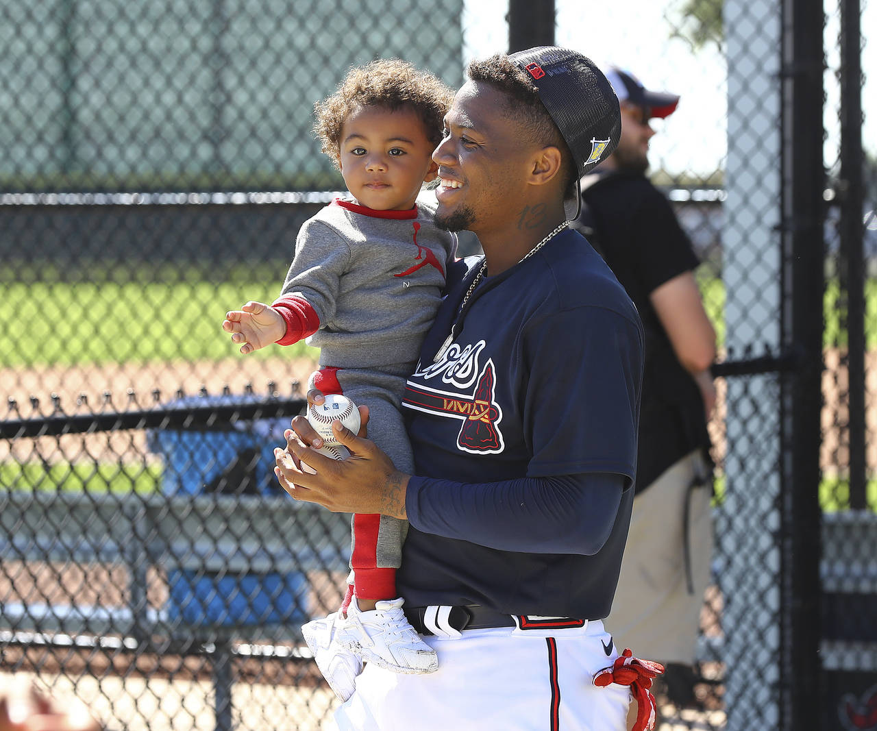 Atlanta Braves outfielder Ronald Acuna smiles with his son Ronald Acuna Jr. at baseball spring trai...