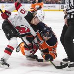 
              New Jersey Devils' Jesper Boqvist (70) and Edmonton Oilers' Leon Draisaitl (29) battle for the puck during the second period of an NHL hockey game in Edmonton, Alberta, Saturday, March 19, 2022. (Jason Franson/The Canadian Press via AP)
            
