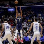 
              New Orleans Pelicans guard CJ McCollum (3) shoots over Orlando Magic guard Jalen Suggs (4) and center Wendell Carter Jr. (34) during the second quarter of an NBA basketball game in New Orleans, Wednesday, March 9, 2022. (AP Photo/Derick Hingle)
            