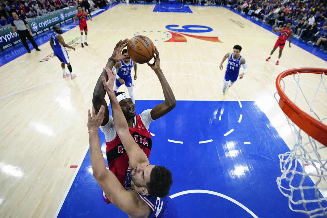 Toronto Raptors' Chris Boucher, top, tries to get a shot past Philadelphia 76ers' Georges Niang dur...