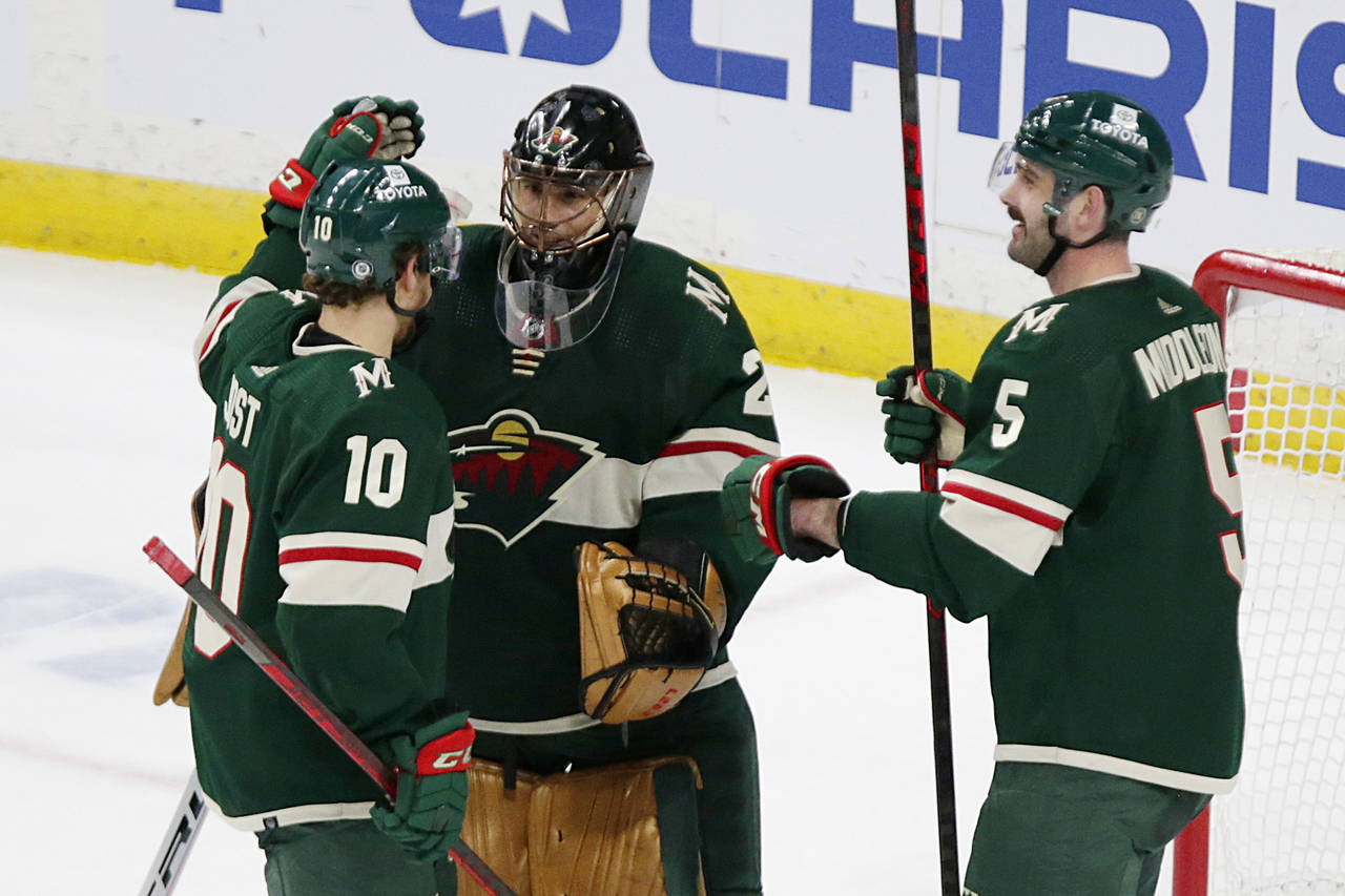 Minnesota Wild goaltender Marc-Andre Fleury (29) is congratulated by teammates Tyson Jost (10) and ...