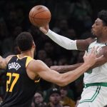 
              Boston Celtics guard Marcus Smart, right, drives to the basket against Utah Jazz center Rudy Gobert (27) during the first half of an NBA basketball game Wednesday, March 23, 2022, in Boston. (AP Photo/Charles Krupa)
            