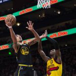 
              Golden State Warriors guard Damion Lee (1) scores over Atlanta Hawks guard Delon Wright (0) during the second half of an NBA basketball game Friday, March 25, 2022, in Atlanta. (AP Photo/Hakim Wright Sr.)
            