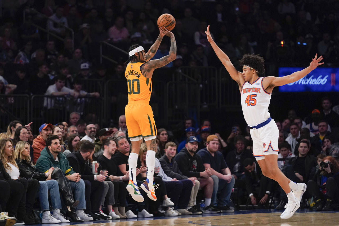 Utah Jazz's Jordan Clarkson, left, shoots over New York Knicks' Jericho Sims during the first half ...