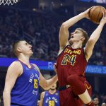 
              Cleveland Cavaliers' Lauri Markkanen (24) shoots against Denver Nuggets' Nikola Jokic (15) during the first half of an NBA basketball game, Friday, March 18, 2022, in Cleveland. (AP Photo/Ron Schwane)
            