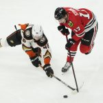 
              Anaheim Ducks' Trevor Zegras (46) falls to the ice as he and Chicago Blackhawks' Dylan Strome reach for the loose puck during the first period of an NHL hockey game Tuesday, March 8, 2022, in Chicago. (AP Photo/Charles Rex Arbogast)
            