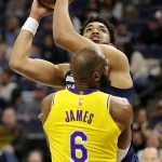 
              Minnesota Timberwolves center Karl-Anthony Towns (32) shoots over Los Angeles Lakers forward LeBron James (6) during the first half of an NBA basketball game Wednesday, March 16, 2022, in Minneapolis. (AP Photo/Andy Clayton-King)
            